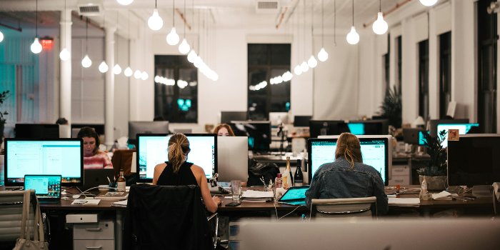 Arbeidsplass med åpent kontorlandskap, fire kvinner som jobber ved hver sin datamaskin.